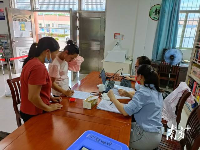 鎮、村干部為村民進行接種信息錄入。